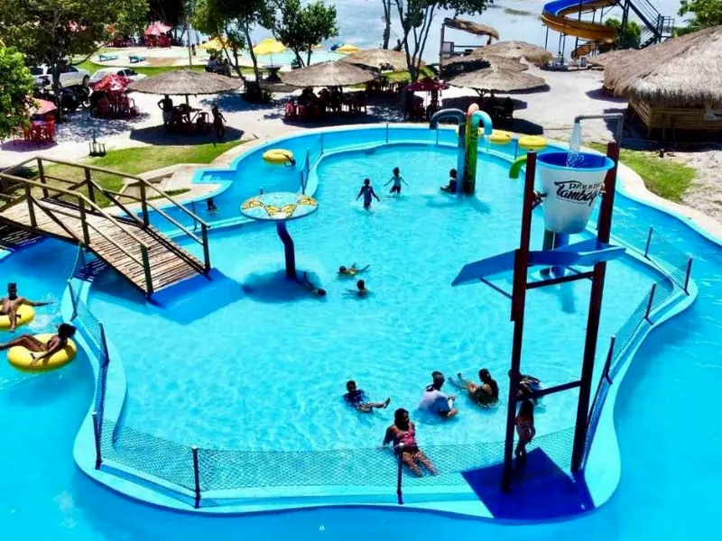 Piscina kids com brinquedos de água, ponte de madeira e crianças brincando